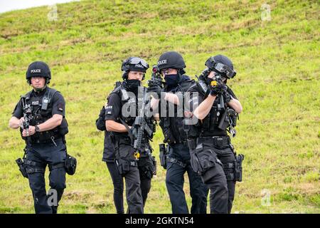 Gli ufficiali di polizia del Dipartimento di polizia del Northamptonshire avanzano la loro posizione durante un esercizio di risposta attiva dello sparatutto a tre agenzie alla RAF Croughton, Inghilterra, 30 giugno 2021. Gli airman del 422° Squadron delle forze di sicurezza insieme agli ufficiali di polizia della NHPD e del Ministero della Difesa, hanno partecipato a molteplici esercizi per migliorare le loro tattiche di ricerca e sequestro, rafforzare i legami locali e ottenere rapporti con i loro compagni di polizia. Foto Stock