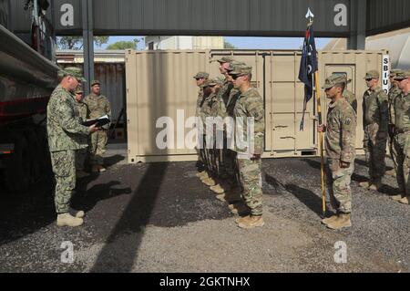 Guardia costiera degli Stati Uniti, CMdR. Benjamin Lehrfeld, comandante del Task Group 68.6, presenta il premio di Comendation Team Meritorious della Guardia Costiera a 12 soldati dell'esercito degli Stati Uniti assegnati alla Dagger Company, 1-102d fanteria (montagna), 86th Infantry Brigade Combat Team, Task Force Iron Grey, a Camp Lemonnier, Gibuti, 30 giugno 2021. Il Coast Guard Meritorious Team Comendation è premiato per l'esecuzione di azioni eccezionali di gruppi riconosciuti che mostrano coesione e lavoro di squadra notevole ai superiori comandanti echelon. Viene assegnato a gruppi o squadre che non sono identificati come unità della Guardia Costiera degli Stati Uniti Foto Stock