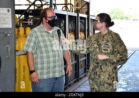 Codice 930 il responsabile della zona di riparazione additiva Nick Allen condivide i recenti sforzi del Cold Spray Team con il comandante del cantiere navale di Norfolk, Capt. Dianna Wolfson, durante le riprese del quinto episodio del cantiere navale americano. Foto Stock