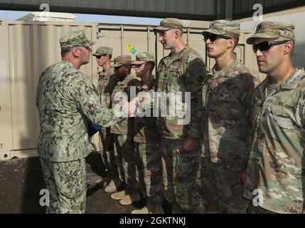 Guardia costiera degli Stati Uniti, CMdR. Benjamin Lehrfeld, comandante del Task Group 68.6, presenta il premio di Comendation Team Meritorious della Guardia Costiera a 12 soldati dell'esercito degli Stati Uniti assegnati alla Dagger Company, 1-102d fanteria (montagna), 86th Infantry Brigade Combat Team, Task Force Iron Grey, a Camp Lemonnier, Gibuti, 30 giugno 2021. Il Coast Guard Meritorious Team Comendation è premiato per l'esecuzione di azioni eccezionali di gruppi riconosciuti che mostrano coesione e lavoro di squadra notevole ai superiori comandanti echelon. Viene assegnato a gruppi o squadre che non sono identificati come unità della Guardia Costiera degli Stati Uniti Foto Stock