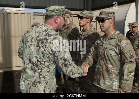 Guardia costiera degli Stati Uniti, CMdR. Benjamin Lehrfeld, comandante del Task Group 68.6, presenta il premio di Comendation Team Meritorious della Guardia Costiera a 12 soldati dell'esercito degli Stati Uniti assegnati alla Dagger Company, 1-102d fanteria (montagna), 86th Infantry Brigade Combat Team, Task Force Iron Grey, a Camp Lemonnier, Gibuti, 30 giugno 2021. Il Coast Guard Meritorious Team Comendation è premiato per l'esecuzione di azioni eccezionali di gruppi riconosciuti che mostrano coesione e lavoro di squadra notevole ai superiori comandanti echelon. Viene assegnato a gruppi o squadre che non sono identificati come unità della Guardia Costiera degli Stati Uniti Foto Stock