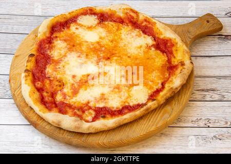 Pizza italiana a cinque formaggi con pomodoro e pasta di grano sottile su tavola di legno Foto Stock