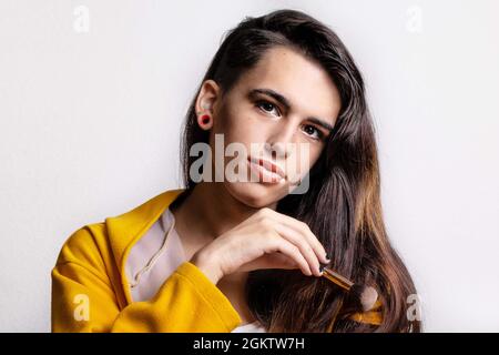 Giovane bella donna ispanica transgender su sfondo bianco Foto Stock