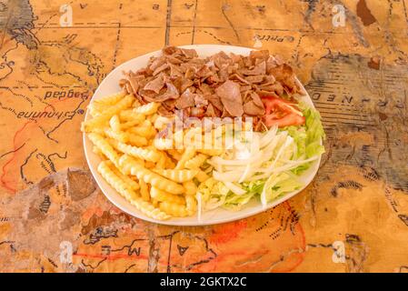 Piatto di carne di agnello al kebab con patatine fritte, insalata e cipolla bianca Foto Stock