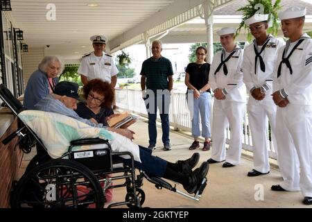 Geraldine Muntz mostra un libro di ricette per suo padre, la seconda guerra mondiale Veteran Baker 2a classe Phil Dorf durante una visita da parte della PCU Massachusetts (SN 798) marinai 2 luglio a Freehold New Jersey. Dorf, che servì a bordo della nave da guerra Massachusetts (BB-58) durante la guerra, fu onorato dai marinai Submariner del sottomarino Virginia Class che presto sarà completato come parte dell'eredità del namesake della nave. Foto Stock