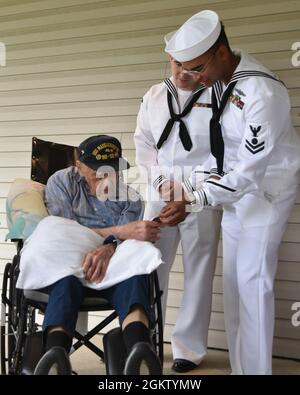 EMN2 Donovan Jordan della PCU Massachusetts (SN 798) presenta una moneta di comando per il veterano della seconda Guerra Mondiale Baker di seconda Classe Phil Dorf durante una visita il 2 luglio a Freehold, New Jersey. Dorf, che servì a bordo della nave da guerra Massachusetts (BB-58) durante la guerra, fu onorato dai marinai Submariner del sottomarino Virginia Class che presto sarà completato come parte dell'eredità del namesake della nave. Foto Stock