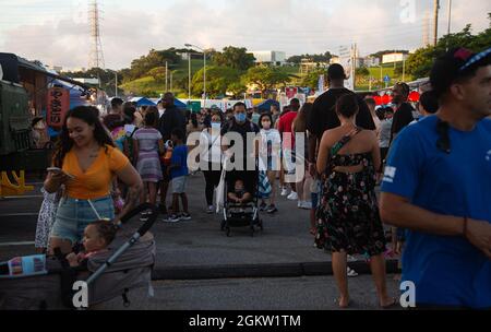 I membri del servizio degli Stati Uniti e le loro famiglie camminano attraverso il Camp Foster Festival su Camp Foster, Okinawa, Giappone, 3 luglio 2021. Marine Corps Community Services organizza ogni anno il Camp Foster Festival per portare cibo, spettacoli e giostre al parco divertimenti per i membri del servizio e le loro famiglie. Foto Stock