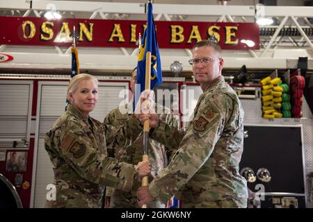 Il Colon. Jonelle Eychner, 51st comandante del gruppo di supporto della Missione, a sinistra, passa il guidon al Lt. Colon. Brian Low, il 51° comandante dello Squadron, ingegnere civile, durante la 51st cerimonia di assunzione del comando da parte del CES presso la base aerea di Osan, Repubblica di Corea, 6 luglio 2021. In qualità di presidente, Eychner ha facilitato la transizione del comando CES 51 presentando la guidon cerimoniale all'ufficiale entrante. Foto Stock