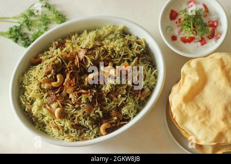 Biriyani verde. Si compone di riso basmati bollente con pasta di chutney di coriandolo verde e spezie e quindi di pollo al curry e carameliz Foto Stock