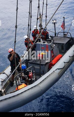 210707-N-CF707-1001 OCEANO PACIFICO (7 luglio 2021) marinai assegnati all'incrociatore classe Ticonderoga USS Lake Champlain (CG 57) abbassare una barca gonfiabile a scafo rigido (RHIB) per il recupero, 7 luglio 2021. Il lago Champlain sta conducendo le operazioni di routine nella terza flotta degli Stati Uniti area delle operazioni. Foto Stock