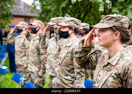 Gli airmen della 501a Ala di sostegno di combattimento, salutano durante una cerimonia di cambio di comando alla RAF Alconbury, Inghilterra, 8 luglio 2021. La cerimonia è una tradizione militare che rappresenta un trasferimento formale dell’autorità e della responsabilità di un’unità da un comandante all’altro. Foto Stock