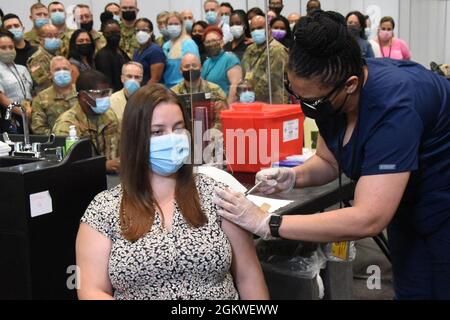 Emma L. Jenks, 21, di Millerton, NY, ottiene una delle ultime vaccinazioni al sito di vaccinazione di massa Jacob K Javits a Manhattan il 9 luglio 2021 prima della fine delle operazioni più tardi quel giorno. Jenks, figlia della Guardia Nazionale dell'Esercito di New York Sgt. Il maggiore Robert ha ricevuto la sua seconda vaccinazione Pfizer da Nurse Christina Davis-Riley, e New York Air National Guard Tech. SGT. Mark Manual, un membro 105th Airlift Wing , che ha servito come tecnico di immissione dati. I rappresentanti delle varie agenzie che comprendevano il Joint Task Javits hanno assistito all'occasione. Foto Stock