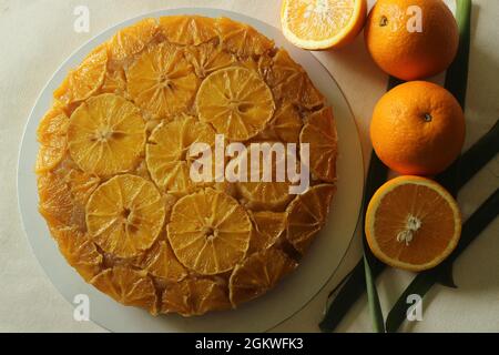 Torta capovolta all'arancia con fette d'arancia sulla parte superiore. Scatto su sfondo bianco. Foto Stock