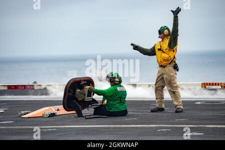 210712-N-IW069-1094 OCEANO PACIFICO (12 luglio 2021) i marinai segnalano a un aereo prima di lanciarlo sul ponte di volo della portaerei di classe Nimitz USS Carl Vinson (CVN 70), 12 luglio 2021. Vinson sta attualmente conducendo operazioni marittime di routine nella terza flotta statunitense. Foto Stock