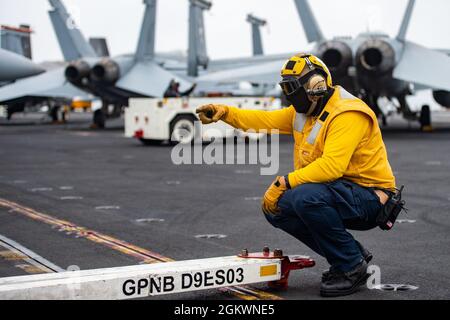 210712-N-IW069-1004 OCEANO PACIFICO (12 luglio 2021) Un Sailor dirige un trattore sul ponte di volo del vettore aereo di classe Nimitz USS Carl Vinson (CVN 70), 12 luglio 2021. Vinson sta attualmente conducendo operazioni marittime di routine nella terza flotta statunitense. Foto Stock