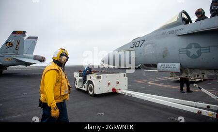 210712-N-IW069-1023 OCEANO PACIFICO (12 luglio 2021) Un Sailor manovra un Super Hornet F/A-18E sul ponte di volo del vettore aereo di classe Nimitz USS Carl Vinson (CVN 70), 12 luglio 2021. Vinson sta attualmente conducendo operazioni marittime di routine nella terza flotta statunitense. Foto Stock