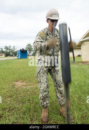 Costruzione elettricista 2a classe Blake Freeman, da Marietta, Oklahoma, assegnato al Battaglione Navale Mobile Construction (NMCB) 133, utilizza un pilota di palo posta per assicurarsi una partecipazione durante un esercizio di formazione sul campo (FTX) a Camp Shelby, luglio 12. FTX è un'evoluzione formativa in cui le forze Seabee pianificano ed eseguono molteplici attività essenziali di missione, tra cui la sicurezza dei convogli, la protezione della forza e la configurazione del campo prima dell'implementazione. Foto Stock