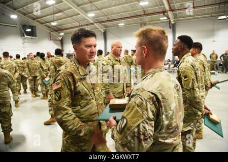 Il generale Brigadier Jonathan S. Hubbard, comandante del 184° comando di supporto, premia e parla con un soldato alla cerimonia di premiazione COVID a Meridian, Mississippi, il 13 luglio 2021. La Guardia Nazionale del Mississippi ha schierato oltre 1,700 guardiani per lavorare insieme a MSDH e MEMA per combattere la diffusione di COVID-19 durante la pandemia. Foto Stock