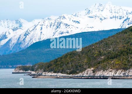 Costa rocciosa e montagne innevate lungo il passaggio interno, Alaska Foto Stock