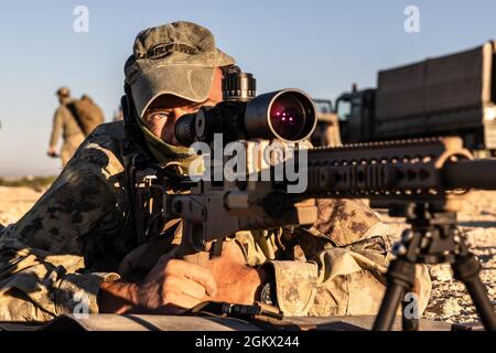 Un cecchino delle forze speciali italiane guarda al ribasso i suoi obiettivi durante le prove di tiro al mattino al corso Desert Sniper del Centro Internazionale di formazione Specialistica a Chinchilla, in Spagna, il 15 luglio 2021. ISTC è una struttura multinazionale di istruzione e formazione per la formazione a livello tattico, avanzato e specializzato di forze multinazionali di operazioni speciali e unità analoghe, che si avvale delle competenze di istruttori multinazionali ed esperti in materia. Foto Stock