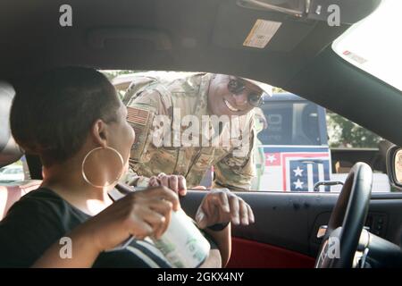 Il col. Phelemon Williams, comandante del gruppo di supporto della missione 436th, saluta le famiglie e consegna i rinfreschi alla cena delle famiglie schierate sulla base dell'aeronautica di dover, Delaware, 15 luglio 2021. I gruppi provenienti da tutta la 436a Ala Airlift si alternano ad ospitare l'evento trimestrale per ringraziare i membri della famiglia mentre i loro cari sono schierati. Foto Stock