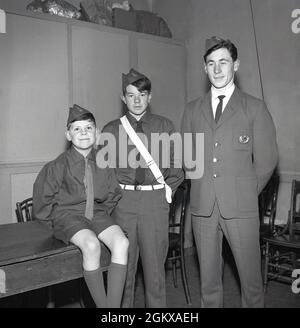 1966, storico, The Boys Brigade, tre ragazzi che indossano le loro uniformi BB, Fife, Scozia, Regno Unito. Fondata come movimento giovanile cristiano a Glasgow, Scozia nel 1883 da William Alexander Smith, l'idea di un gruppo giovanile in uniforme era una nuova idea a quel tempo. L'immagine qui mostra tre ragazzi di diverse età che indossano ridisegnato BB uniforme. Tutti e tre con il tradizionale cappuccio BB, ma solo il ragazzo al centro indossando la cintura. A questo punto, la Brigata riorganizzò la Sezione Junior, precedentemente conosciuta come i Life Boys, fu introdotto Un nuovo programma di Achivement della Sezione Junior. Foto Stock