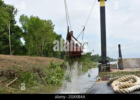 Gli operatori di attrezzature pesanti del corpo degli ingegneri dell'esercito degli Stati Uniti, Memphis District Clearing & Snagging Unit, sono i primi team in un'area a prepararla per l'infrastruttura di revisione necessaria per mantenere l'integrità del canale lungo il fiume Mississippi e i suoi principali affluenti. Il team si affida a attrezzature pesanti come questa gru e la benna, con la sua capacità di sollevamento di 120 tonnellate, per eliminare la vegetazione e i detriti durante la stagione di 8 mesi che va da luglio a marzo. Foto Stock