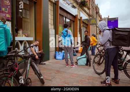 Un certo numero di motociclisti di consegna di fast food si riuniscono fuori da un McDonalds nel centro di Leicester. Foto Stock