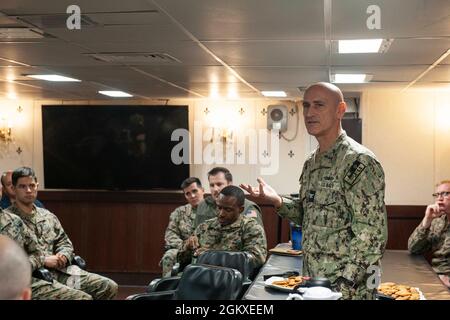 210718-N-XB010-1029 CORALLO MARE (18 luglio 2021) il capt. Greg Baker, Commodore, Amphibious Squadron 11, si rivolge a USS New Orleans (LPD 18) leadership nel wardroom. New Orleans, parte dell'America Expeditionary Strike Group, insieme alla 31st Marine Expeditionary Unit, sta operando nell'area di responsabilità della 7th Fleet statunitense per migliorare l'interoperabilità con alleati e partner e fungere da forza di risposta pronta per difendere la pace e la stabilità nella regione indopacifica. Foto Stock