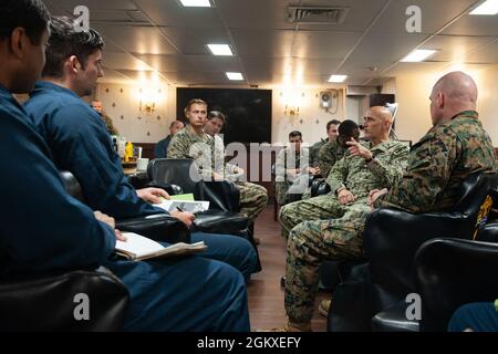 210718-N-XB010-1032 CORALLO MARE (18 luglio 2021) Cap. Greg Baker, Commodore, Amphibious Squadron 11, secondo da destra, si rivolge USS New Orleans (LPD 18) leadership nel wardroom. New Orleans, parte dell'America Expeditionary Strike Group, insieme alla 31st Marine Expeditionary Unit, sta operando nell'area di responsabilità della 7th Fleet statunitense per migliorare l'interoperabilità con alleati e partner e fungere da forza di risposta pronta per difendere la pace e la stabilità nella regione indopacifica. Foto Stock