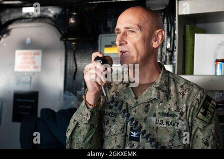 210718-N-XB010-1036 CORALLO MARE (18 luglio 2021) Cap. Greg Baker, Commodore, Amphibious Squadron 11, indirizzi USS New Orleans (LPD 18) sul 1MC sul ponte. New Orleans, parte dell'America Expeditionary Strike Group, insieme alla 31st Marine Expeditionary Unit, sta operando nell'area di responsabilità della 7th Fleet statunitense per migliorare l'interoperabilità con alleati e partner e fungere da forza di risposta pronta per difendere la pace e la stabilità nella regione indopacifica. Foto Stock