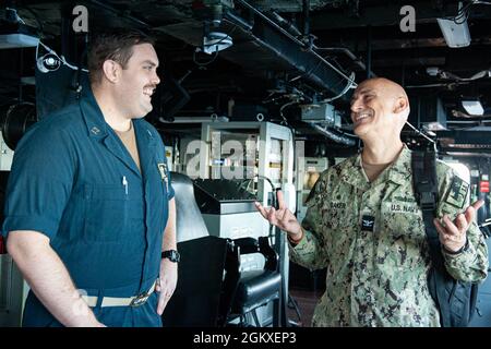 210718-N-XB010-1042 CORALLO MARE (18 luglio 2021) Cap. Greg Baker, Commodore, Amphibious Squadron 11, conversò con il Lt. Andrew Barker, USS New Orleans (LPD 18) Combat Systems officer, sul ponte. New Orleans, parte dell'America Expeditionary Strike Group, insieme alla 31st Marine Expeditionary Unit, sta operando nell'area di responsabilità della 7th Fleet statunitense per migliorare l'interoperabilità con alleati e partner e fungere da forza di risposta pronta per difendere la pace e la stabilità nella regione indopacifica. Foto Stock