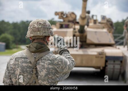 Un Master Gunner studente dell'esercito degli Stati Uniti, assegnato al 3rd Squadron, 16th Calvary Regiment, usa i segnali di mano e di braccio per dirigere un M1A2 SEP V2 Abrams Tank dove muoversi a Ware Range, Fort Benning, GA., 20 luglio 2021. Queste petroliere si stanno allenando per diventare Mater Gunners, ed essere esperti in materia nel loro campo. Foto Stock