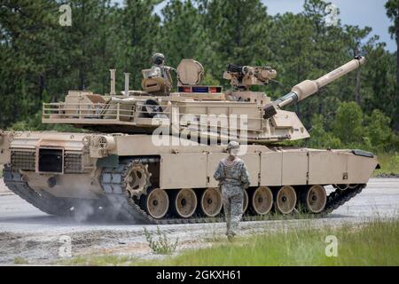 Uno studente del Maestro dell'esercito degli Stati Uniti Gunner, assegnato al terzo Squadron, 16° Reggimento del Calvario, cammina come guida di terra sul lato di M1A2 SEP V2 Abrams Tank a Ware Range, Fort Benning, GA., 20 luglio 2021. Queste petroliere si stanno allenando per diventare Mater Gunners, ed essere esperti in materia nel loro campo. Foto Stock