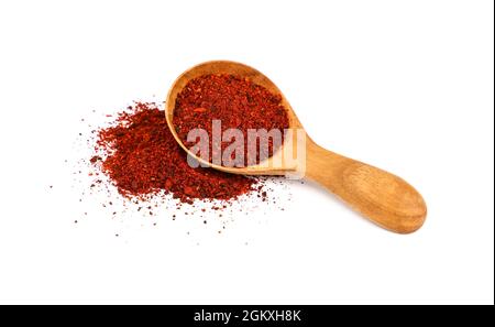 Primo piano un cucchiaio di legno pieno di pomodori secchi macinati, cumulo di polvere versato intorno, isolato su sfondo bianco, vista ad angolo alto Foto Stock