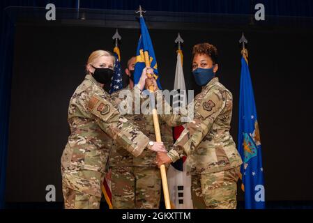 Jonelle Eychner, 51st comandante del gruppo di supporto della Missione, a sinistra, presenta il guidon cerimoniale al terzo Colon. Tamokia Payne, 51st comandante in entrata del supporto della forza Squadron, presso la base aerea di Osan, Repubblica di Corea, 21 luglio 2021. Da questo momento in poi, Payne è ora ufficialmente il comandante della 51esima FSS. Foto Stock