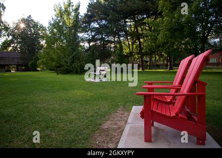 Tramonto sul parco pubblico con le sedie Adirondack. Foto Stock