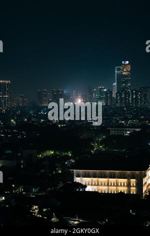 GIACARTA, INDONESIA - 07 luglio 2021: Uno scatto verticale di uno skyline di Jakarta Indonesia di notte con una vista di impressionanti luci al neon Foto Stock