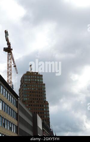 Distretto finanziario di Rotterdam, Paesi Bassi, con una gru da cantiere tra gli edifici. Vista verticale ad angolo basso con cielo nuvoloso sullo sfondo. Foto Stock