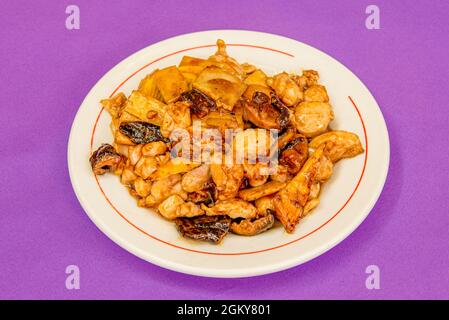 Ricetta cucinata da uno chef asiatico di manzo stufato con bambù e funghi cinesi con salsa di soia su tavola viola Foto Stock