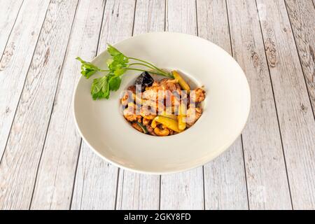 Delizioso piatto di pollo al kung pao con noci di anacardi, verdure e funghi cinesi, pepe di Sichuan, aceto di riso e salsa di soia Foto Stock