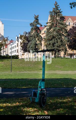 Helsinki / Finlandia - 10 SETTEMBRE 2021: Primo piano di uno scooter elettrico contro il parco pubblico urbano. Foto Stock