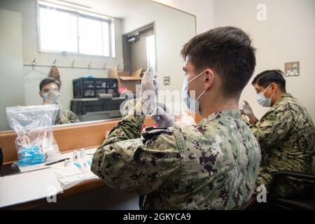 Ospedale Corpsman terza classe Andrew Calavaza e Hospitalman Michael Munchrat, assegnato al US Naval Hospital Yokosuka Branch Health Clinic Sasebo, prepara dosi del vaccino Moderna COVID-19 per la somministrazione al Japanese Master Labor Contract (MLC), Indirect Hire Agreement (IHA), E Mariner’s Contract (MC) dipendenti del Commander, Fleet Activities Sasebo’s (CFAS) Showboat Theatre 28 luglio 2021. Con l'autorizzazione del governo del Giappone, la CFAS ha iniziato a somministrare vaccini a dipendenti locali giapponesi impiegati sulla base, giugno 23. Foto Stock