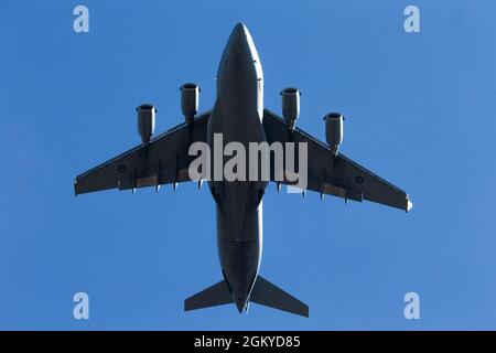 Un Royal Australian Air Force Boeing C-17 Globemaster III è utilizzato come parte di un'operazione simulata di entrata forzata del giunto per far cadere i paracadutisti dell'esercito degli Stati Uniti in Alaska in una zona di caduta Kangaroo assicurata durante l'esercizio Talisman Saber 21 in Charters Towers, Queensland, Australia, 28 luglio 2021. Questo evento fa parte di un più ampio JFEO simulato superstato dal quarto posto di comando in avanti della Divisione di fanteria degli Stati Uniti, che funge da quartier generale del comando delle componenti delle forze terrestri per questa parte di TS21. TS21 supporta la strategia di difesa nazionale degli Stati Uniti migliorando la capacità di proteggere la patria e. Foto Stock