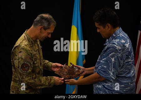 Ken Wilsbach, a sinistra, comandante delle forze aeree del Pacifico, riceve un regalo dal presidente della Repubblica di Palau Surangel Whipps Jr. A Camp Katuu, Palau, 28 luglio 2021. Wilsbach si è recato a Palau per discutere le possibilità di rafforzare ulteriormente il rapporto tra USAF e Palau. Foto Stock