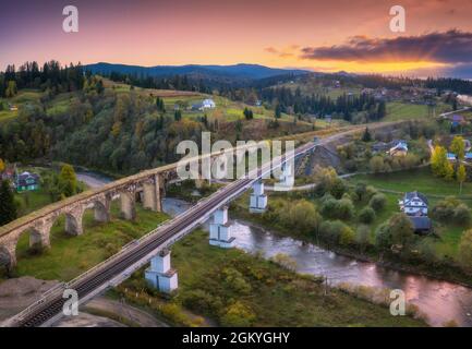 Bellissimo viadotto vecchio al tramonto in carpazi montagne in autunno Foto Stock