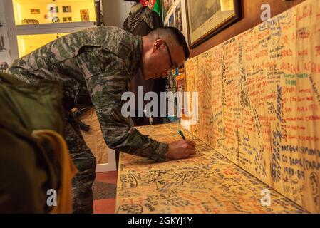 Sugiovane Kim, un dirigente con la 1a Divisione Marine, firma il suo nome durante una visita al 3rd Battaglione, il museo del reggimento reale australiano all’Exercise Talisman Saber 21 a Lavarack Barracks, Queensland, Australia, 30 luglio 2021. TS21 supporta la strategia di difesa nazionale degli Stati Uniti migliorando la capacità di proteggere la patria e fornire forze credibili da combattimento per affrontare l'intera gamma di potenziali preoccupazioni di sicurezza nell'Indo-Pacifico. Foto Stock