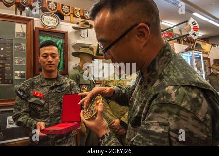 SuYoung Kim, un dirigente senior presso la 1a Divisione Marine, presenta un regalo ai volontari del museo durante una visita al 3rd Battaglione, il museo del reggimento reale australiano all'Exercise Talisman Saber 21 a Lavarack Barracks, Queensland, Australia, 30 luglio 2021. TS21 supporta la strategia di difesa nazionale degli Stati Uniti migliorando la capacità di proteggere la patria e fornire forze credibili da combattimento per affrontare l'intera gamma di potenziali preoccupazioni di sicurezza nell'Indo-Pacifico. Foto Stock