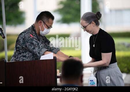 Il Colon. Takashi Izuhara, Giappone Air Self-Defense Forces Operations Support Wing Commander, e Leslie Jones, 374th Airlift Wing storico, presentano un contributo alla sepoltura Time Capsule presso Yokota Air base, Giappone, 29 luglio 2021. JASDF ha contribuito alla capsula del tempo che rappresenta il legame tra gli Stati Uniti e il Giappone. Foto Stock