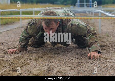 SGT. 1° Classe Shane Price, 108th Training Command, striscia sotto un ostacolo al corso di terra ostacolo durante la competizione militare della Confederazione Interallied degli ufficiali di riserva a Lahti, Finlandia, il 31 luglio. Il MILCOMP del CIOR è un concorso annuale tra la NATO e il partenariato per le nazioni della Pace. Questo concorso prova i membri del servizio di riserva da nazioni alleate su diverse discipline di base in squadre di tre. Foto Stock